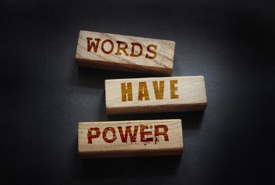 Table sur laquelle sont posées des morceaux de bois qui disent que les mots ont du pouvoir